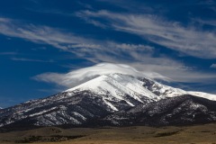 Cap cloud on snowy peak